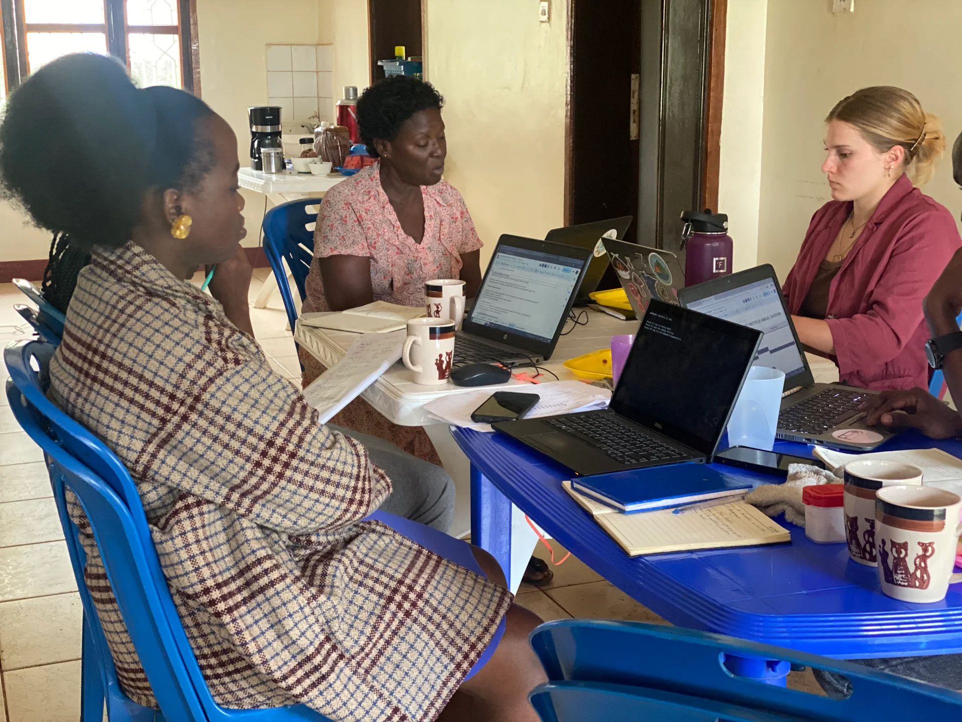 FOSCOD colleagues and a participant collaborating at laptops
